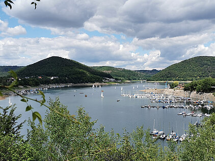 Auf einer Ruhebank sitzend hat man den herrlichen Blick auf Rehbach und auf den Yachthafen.